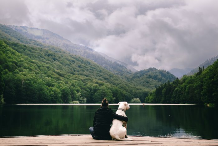 mujer con perro en el lago